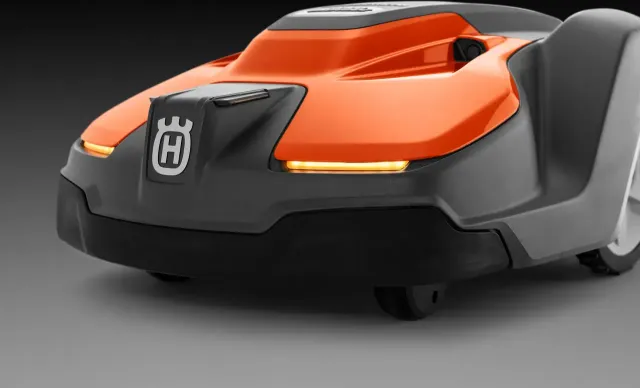 Вид спереду на роботизовану газонокосарку Husqvarna з елегантним дизайном і фарами.