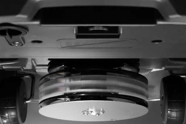 Вид знизу на роботизовану газонокосарку, на якій видно її леза, що обертаються.